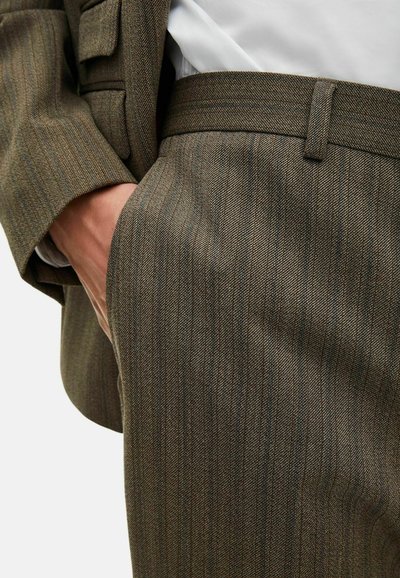 Bruine pinstripe broek gemaakt van een gestructureerde stof met een slim fit. Beschikt over een vlakke voorkant, riemlussen en een zijzak.