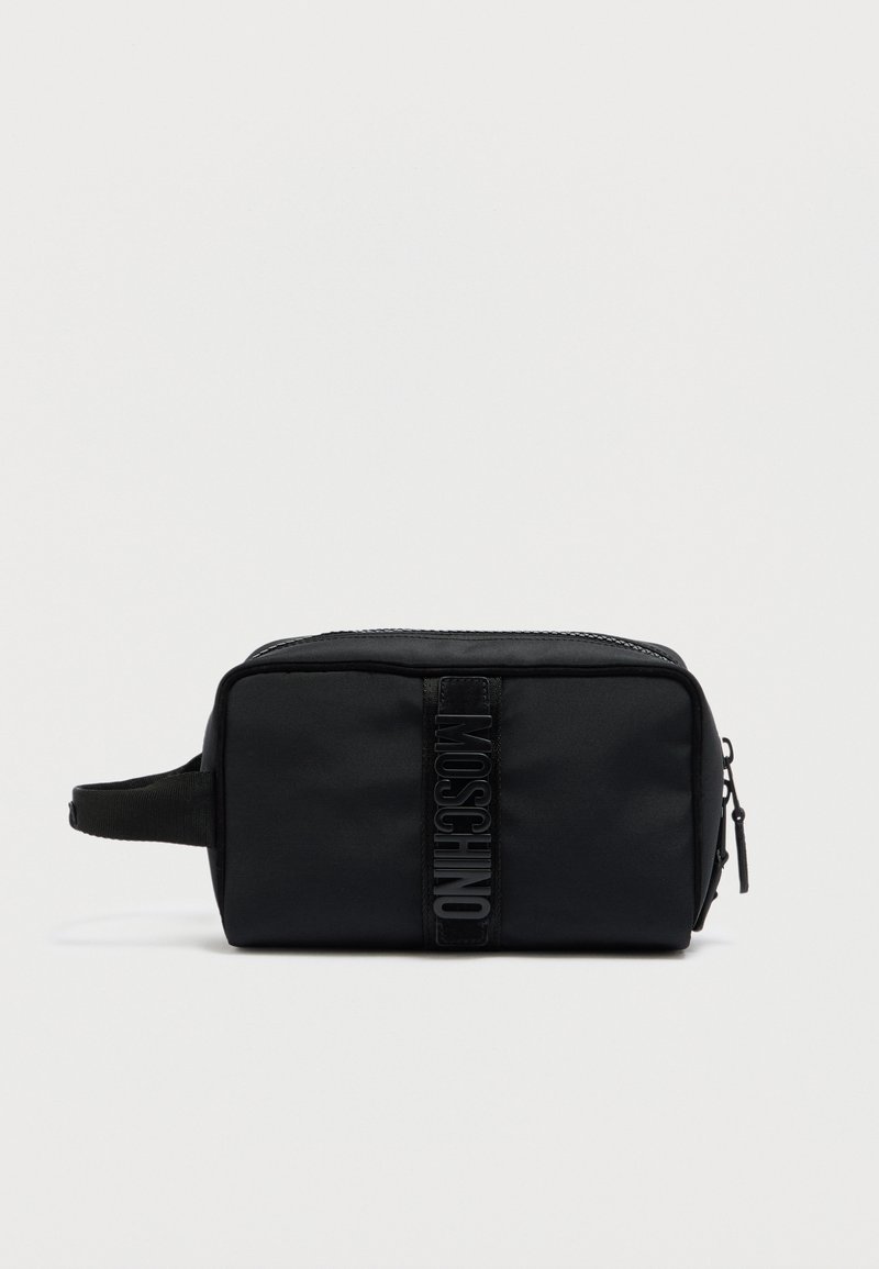 Trousse de toilette noire de forme rectangulaire. Fabriquée en tissu texturé avec une fermeture éclair. Présente une sangle logo noire bien visible à l'avant.