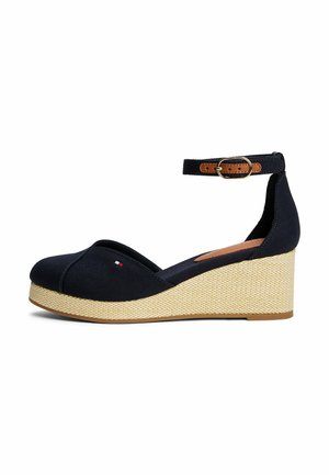 Sandalo con zeppa blu navy con suola platform beige con texture, cinturino regolabile marrone alla caviglia con fibbia dorata e piccolo logo sull'area delle dita.