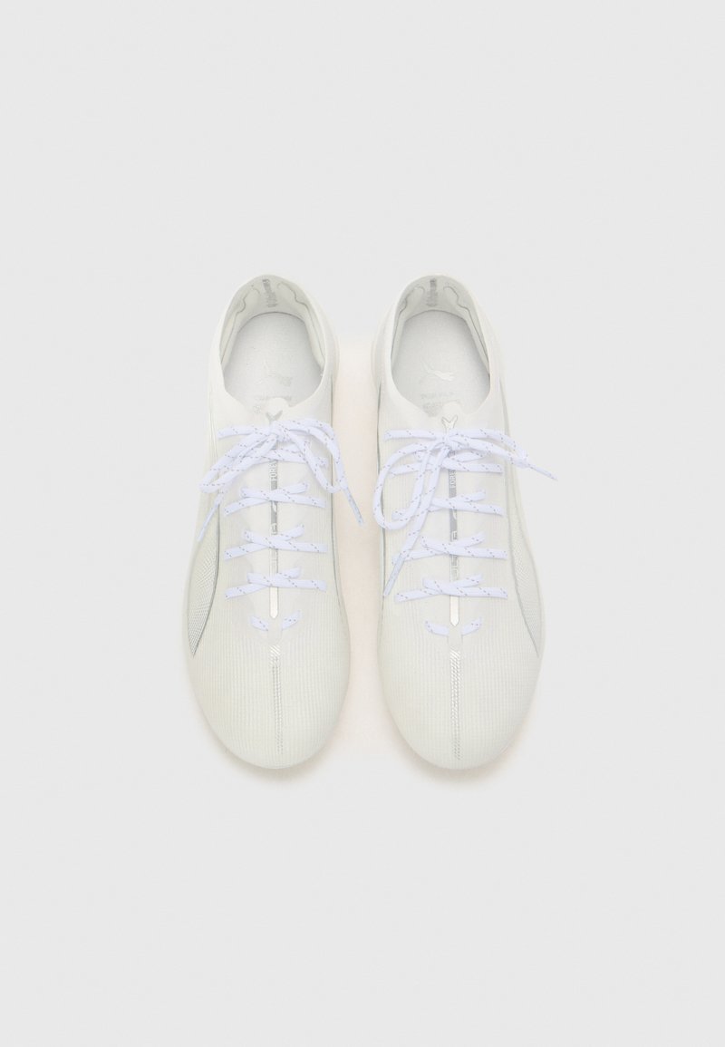 Zapatillas deportivas blancas con un upper texturizado, cordones planos y un diseño minimalista. Presentan una forma esbelta y un sutil detalle de costura lateral.