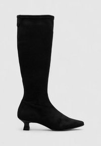 Botas negras hasta la rodilla hechas de material suave. Presentan una punta afilada, un tacón bajo tipo kitten y un diseño liso y sin costuras con un acabado sutil.