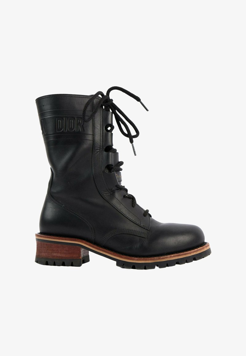 Botte mi-mollet en cuir noir à lacets, talon en bois empilé, semelle rainurée et détail embossé "Dior" près du haut.