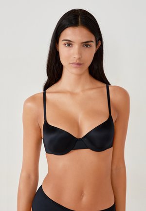 Reggiseno in satin nero con spalline sottili, coppe morbide e una superficie liscia. Presenta un design senza cuciture e un sottile dettaglio di cucitura centrale.
