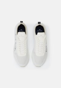 Paire de baskets blanches Paul Smith avec texture en mesh, laçage à l'avant et logo noir manuscrit sur le côté et la semelle intérieure.