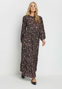 Musta kukkakuosis maxi-mekko, jossa on pitkät hihat, kootut vyötärö ja pieniä monivärisiä kukkakuvioita. Sujuva kangas, joka luo virtaavan siluetin.