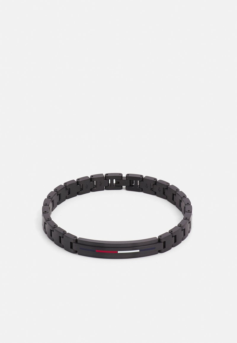 Svart armbånd med sammenkoblede lenker, jevn tekstur og en sentral detalj med tynne horisontale striper i rødt, hvitt og blått.