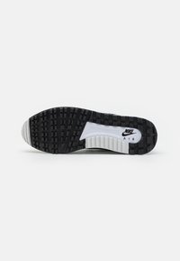 Sola de sneaker preto e cinza com padrão de borracha texturizada, apresentando um amortecedor de ar visível e detalhes em branco. Logótipo da Nike na entressola.