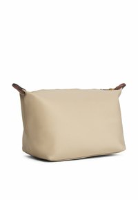 Borsa cosmetica beige con cerniera dalla forma strutturata, realizzata in materiale morbido. Presenta dettagli in pelle marrone e una texture liscia.