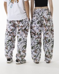 Weiße gemusterte Hose mit einem Tarnmuster aus Blättern und Ästen. Lockere Passform mit einem elastischen Bund und Taschen.