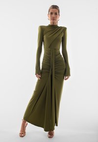 Olivově zelené šaty s dlouhým rukávem, s drapovaným designem, nařasenou texturou a štíhlým střihem. Na podlahu s vysokým rozparkem na stehně.