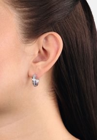 Silverhängeörhängen med flätad design och polerad yta. Utsmyckade med små inbyggda detaljer för extra elegans.