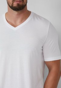 Witte V-hals T-shirt van zachte stof, met een klein, subtiel geborduurd s.Oliver-logo op de linkerkant van de borst. Korte mouwen.