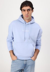Šviesiai mėlynas, laisvo kirpimo hoodie, su raišteliais ir priekinėmis kišenėmis. Viduryje yra mažas baltas logotipas. Pagamintas iš storo medvilninio audinio.