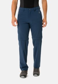 Pantaloni da trekking navy blu con zip rimovibile, realizzati in tessuto leggero. Presentano due tasche con zip e polsini regolabili. Design resistente per l'uso all'aperto.