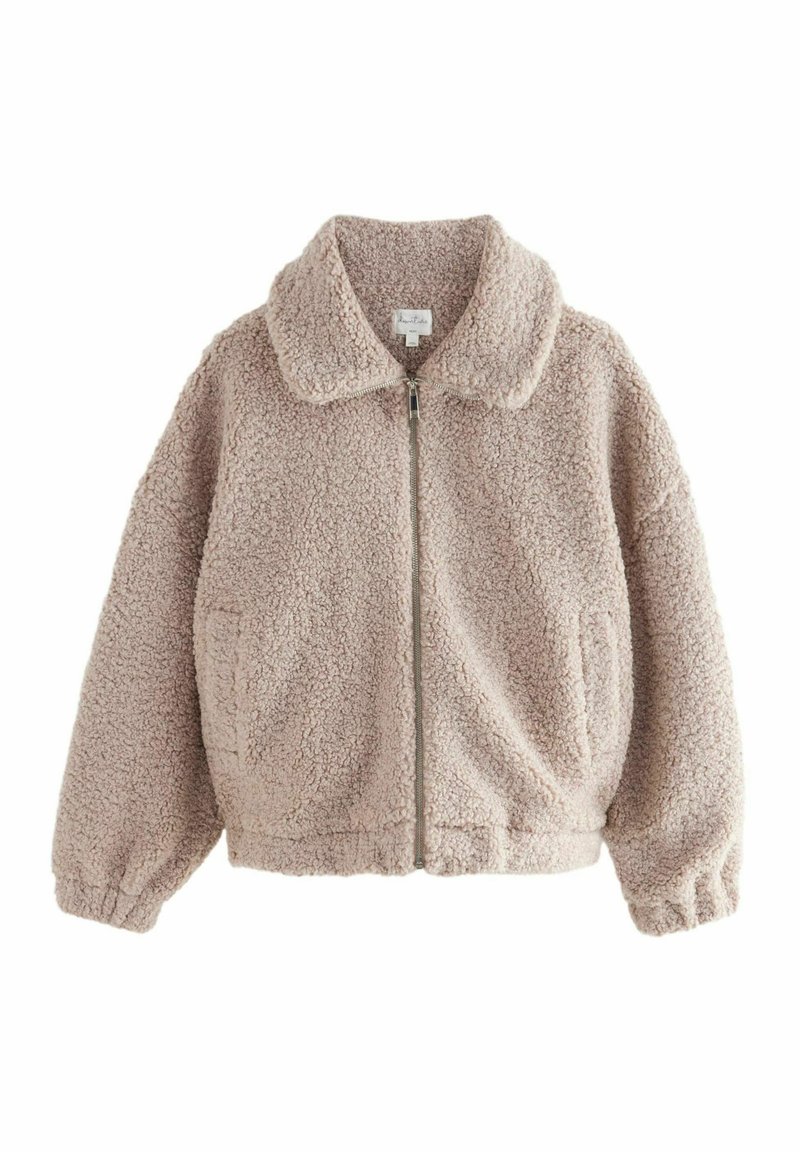 Faux fur jakke i lys beige med krave, elastiske mansjetter og lynlås foran. Den har en blød, tekstureret overflade og sidelommer.