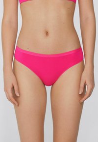 Růžové bikinové kalhotky s hladkou texturou, nízkým pasem a širokým pásem. Materiál je elastický a přiléhavý, vhodný na plavky.