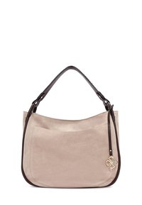 Beige suede handtas met een bruine leren schouderband, gebogen vorm en een decoratief embleem. Heeft een voorkantzak voor extra functionaliteit.