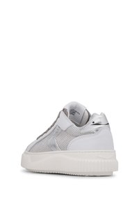 Baskets blanches avec une tige en mesh texturé, des accents argentés et une semelle blanche épaisse. Un col rembourré ajoute du confort.