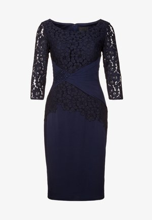 Marineblå knælængde kjole med blomstrede blonder på lange ærmer og krop, med et rynket taljepanel med små perledekorationer.