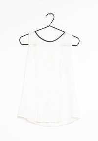 Haut sans manches blanc avec une texture plissée, encolure ronde avec bord noir, suspendu sur un cintre noir contre un fond blanc.