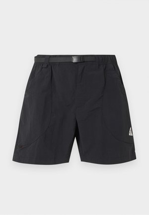 Čierne vonkajšie krátke nohavice s integrovaným nastaviteľným pásom, bočnými vreckami a malým bielym trojuholníkovým logom na pravej nohe.