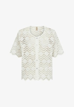 Cardigan à manches courtes en dentelle blanche, présentant un motif en chevrons, un col rond et une fermeture à boutons avec des bords festonnés à l'ourlet.