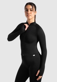 Black athletic jacket with a high collar and zip closure. Features long sleeves with thumbholes and a ribbed texture for flexibility.