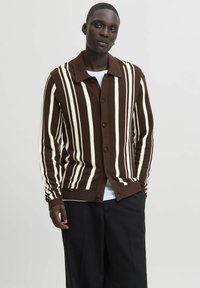 Karamell- und cremefarben gestreifter Strickcardigan mit Knopfverschluss und umklappbarem Kragen, der eine strukturierte Oberfläche und einen lässigen Schnitt aufweist.