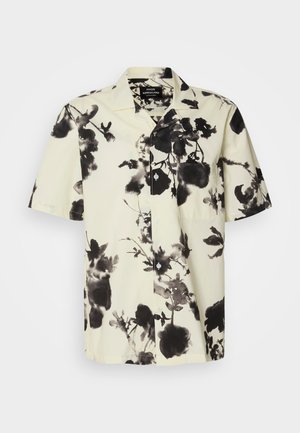 Košeľa s krátkym rukávom s krémovým základom a čiernymi kvetinovými vzormi. Vyrobená z ľahkej tkaniny, má zapínanie na gombíky a vrecko na hrudi.