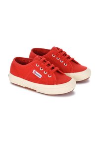 Sneakers di tela rossa con suola in gomma crema, caratterizzati da occhielli e lacci bianchi, punta rotonda e un piccolo logo del marchio sul lato.