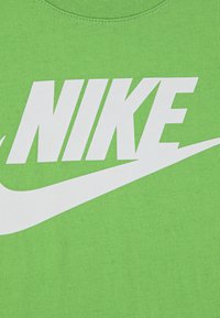Πράσινο βαμβακερό t-shirt με μεγάλο λευκό λογότυπο "NIKE" και λευκό σχέδιο swoosh. Λεία υφή με λαιμόκοψη κοντή.