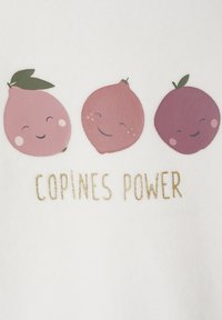 White fabric featuring three smiling fruit designs in pink, with green leaves, and the text "COPINES POWER" in gold glitter below.