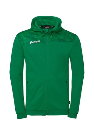 Groene hooded jas met volledige rits, geometrisch patroon op de schouders en "Kempa"-logo op de linkerborst.