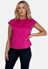 Fuksjowa bluzka z krótkim rękawem o okrągłym dekolcie, z delikatnymi zakładkami na ramionach i gładką, elegancką linią.