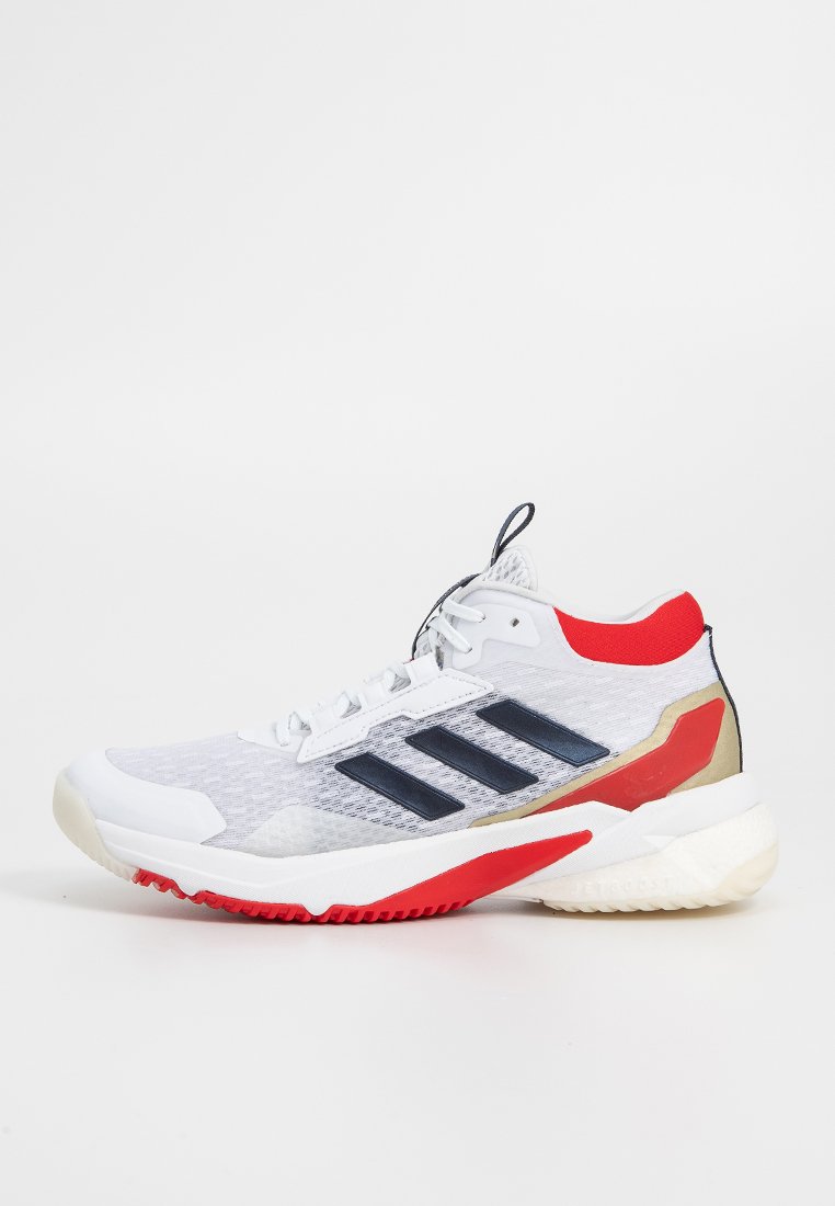 Zapatilla deportiva blanca con parte superior de malla, rayas marinas, acentos rojos y una suela texturizada para agarre. Presenta un collar acolchado y un diseño de cordones.