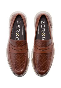 Bruine gevlochten leren loafers met een gladde neus en een contrasterende witte rubberen zool. Voorzien van een klassiek instapmodel en minimale stikdetails.