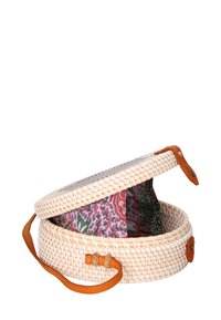 Cesta rotonda intrecciata in paglia naturale con un interno decorato colorato. Presenta una tracolla in pelle e una chiusura a bottone.