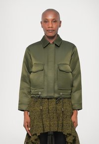 Khaki rohelise värvi lühendatud bomber-jakk satiinviimistluses, millel on kaks esist kotikest, stringiga alus ja klassikaline krae.