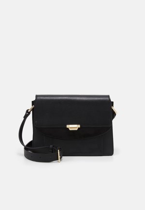 Bolso bandolera de cuero negro con solapa texturizada, cierre dorado y correa ajustable, sobre un fondo blanco liso.