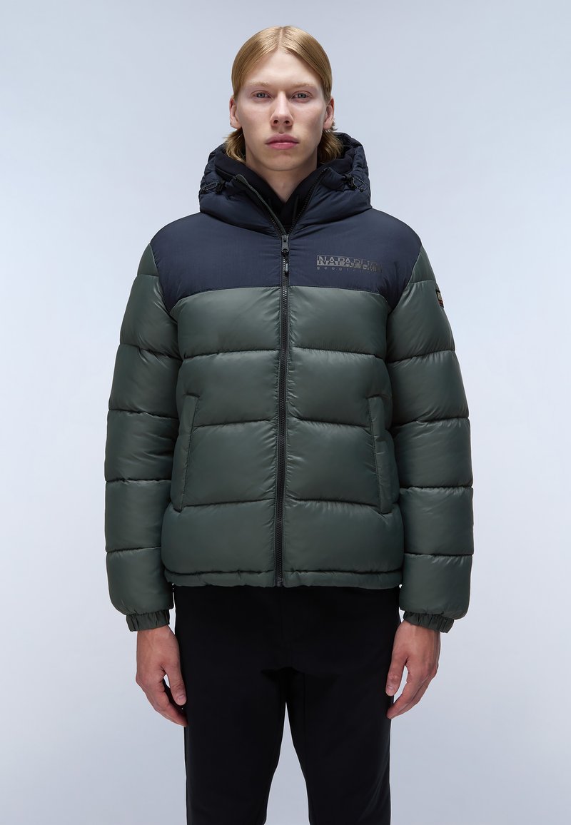 Grüne gepolsterte Jacke mit einem marineblauen oberen Abschnitt, einem Reißverschluss und einer verstellbaren Kapuze. Verfügt über elastische Bündchen und ein Logo auf der Brust.