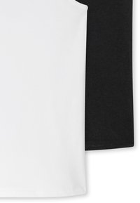 Top in cotone senza maniche in bianco e nero. Il top bianco ha una texture liscia, mentre il top nero presenta un tessuto leggermente testurizzato.