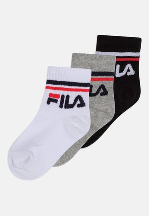 Trois paires de chaussettes de cheville en blanc, gris et noir. Chacune présente une bande rayée avec des accents rouge, blanc et noir et le logo "FILA".