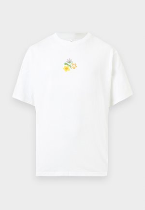 Bela kratka majica s pisanim majhnim cvetličnim vzorcem, ki je na sprednji strani na sredini ob vratu.