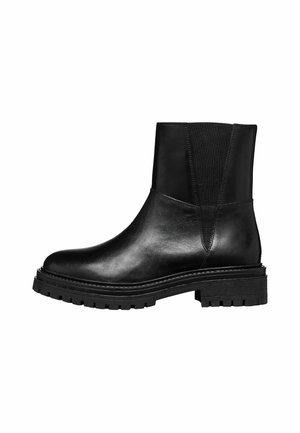 Stivaletto in pelle nera con pannelli laterali elastici, punta arrotondata, suola spessa a ragno e una texture liscia. Presenta un design minimalista e una costruzione robusta.