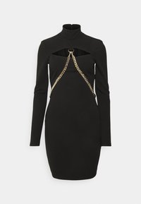 Robe mini noire à manches longues avec col roulé, décolleté au niveau de la poitrine, et détail en chaîne dorée formant une forme triangulaire à l'avant.