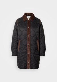 Long manteau noir matelassé avec col en velours côtelé marron, patte de boutonnage devant et bordure de poche, avec des boutons-pression argentés sur le devant.