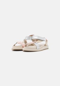 Sandalias plateadas y rosas con parte superior de tela suave, correas ajustables y una suela ligera beige. Diseño simple, correas texturizadas.