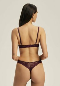 Burgundzkie koronkowe zestaw bielizny z falbaniastymi krawędziami i regulowanymi ramiączkami, z kwiatowym wzorem i zapięciem na haftkę z tyłu.