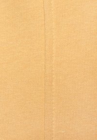 Texturiertes Strickgewebe in einem gedämpften Gelb-Orange, das ein feines Rippenmuster und subtile horizontale Nähte aufweist, mit einem glatten, sanften Erscheinungsbild.