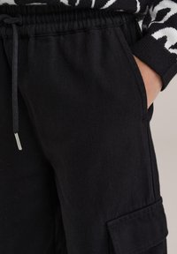 WE Fashion Hlačami s stranskimi žepi - black